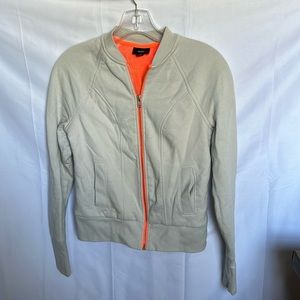 grey zip-up with neon orange trim and lining